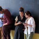 Grup de persoane care navighează pe telefoane, ilustrând importanța unei bune experiențe pe pagină și a optimizării Core Web Vitals.
