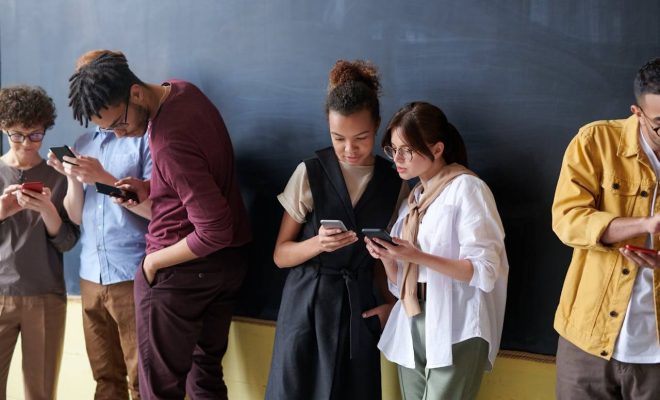 Grup de persoane care navighează pe telefoane, ilustrând importanța unei bune experiențe pe pagină și a optimizării Core Web Vitals.