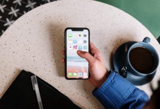 O mână care ține un telefon cu aplicațiile Instagram și Facebook pe ecran, ilustrând datele conform cărora Instagram depășește Facebook în UE.